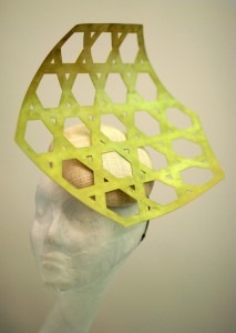 Photograph of an elegant gold netted metal headpiece on a mannequin head.