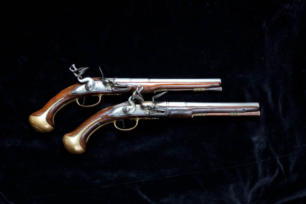 Photograph of two pistols against black background